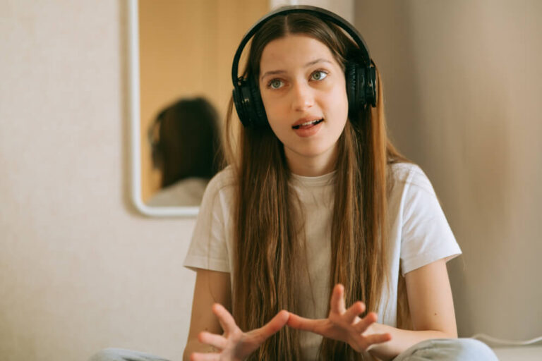 Kobieta ze słuchawkami na uszczach ma kurs językowy online